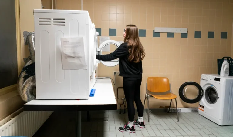 Foto van iemand die was in machine doet.