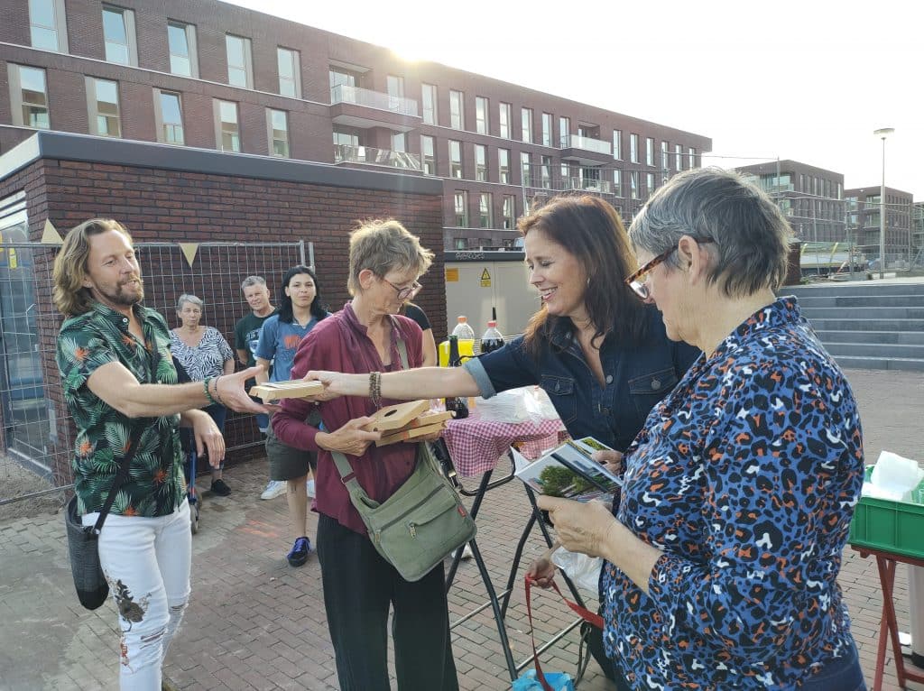 Foto van een groep mensen buiten, bij de opening van de tentoonstelling.