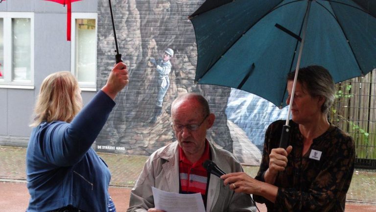 Harry Murë vertelt over Jeanne Immink met op de achtergrond de muurschildering