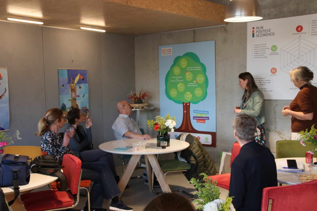 Mensen zitten in een workshopruimte aandacht te luisteren