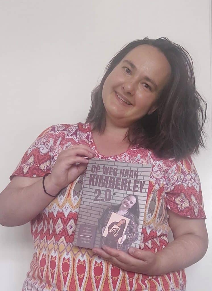 Kimberley de Bruin houdt haar boek vast