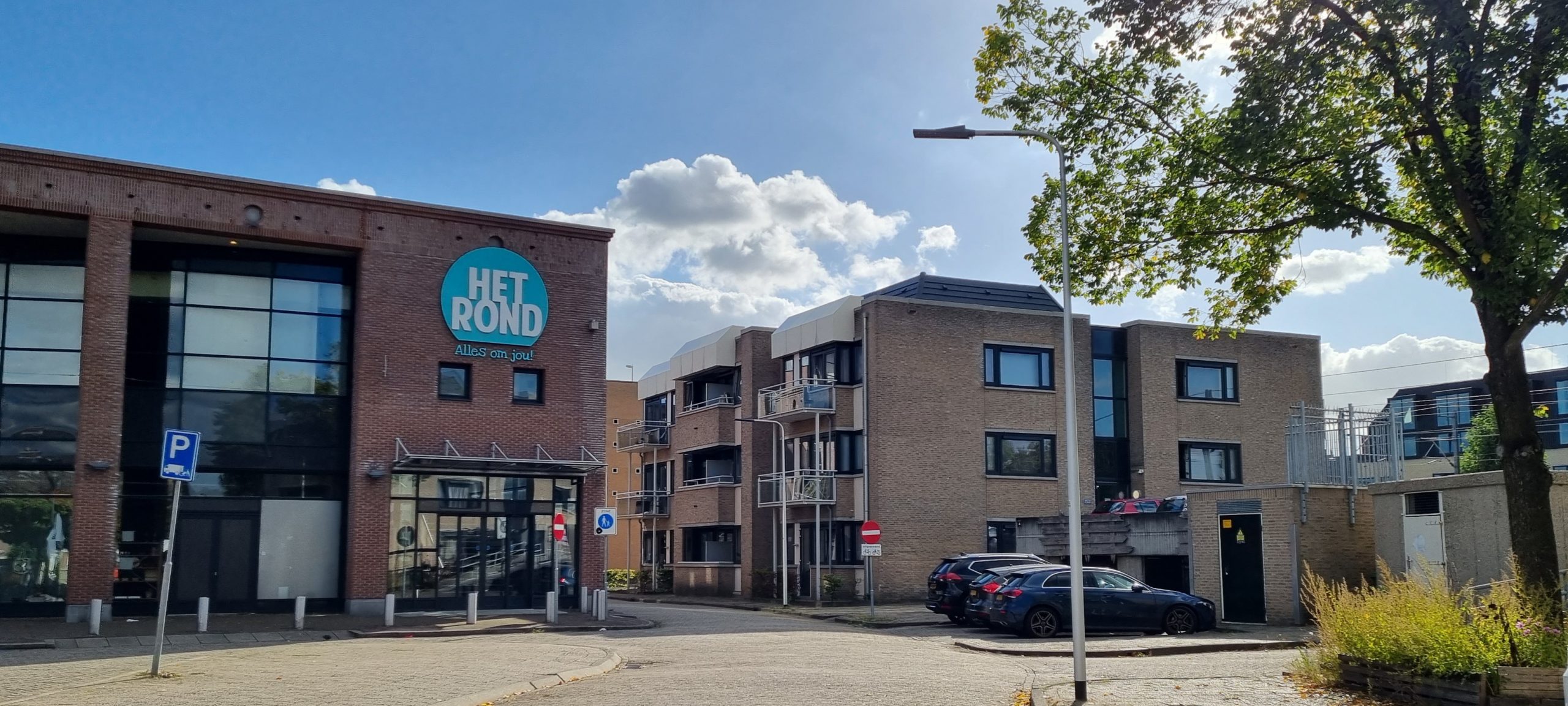 Straat met appartementen van Lister Houten Spoorhaag te zien vanaf een winkelcentrum