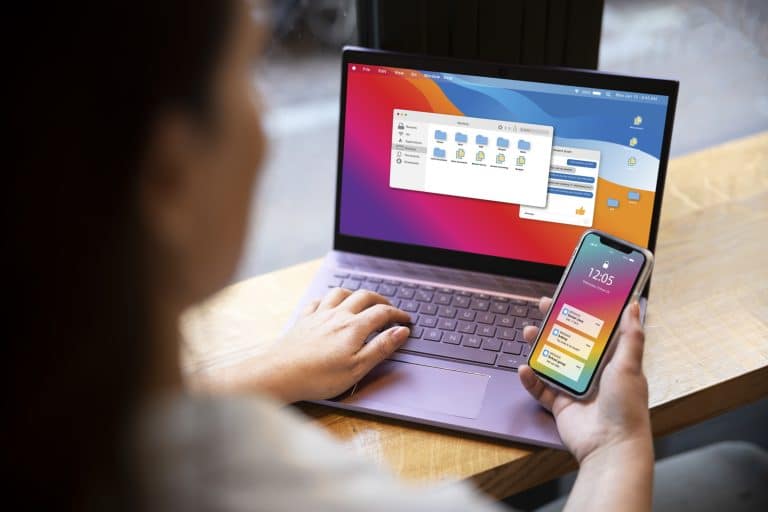 vrouw van achter gezien met laptop en telefoon' op tafel