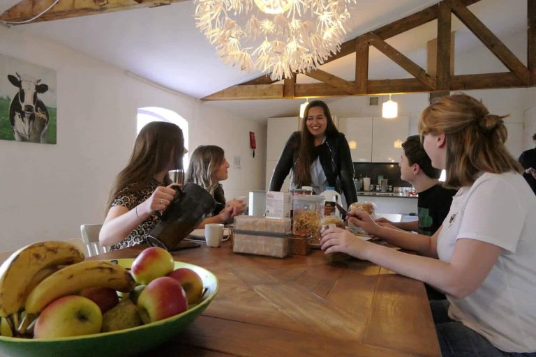 Foto van groep jonge mensen aan tafel.