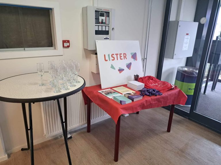 Twee tafels met Lister poster, flyers en glazen.