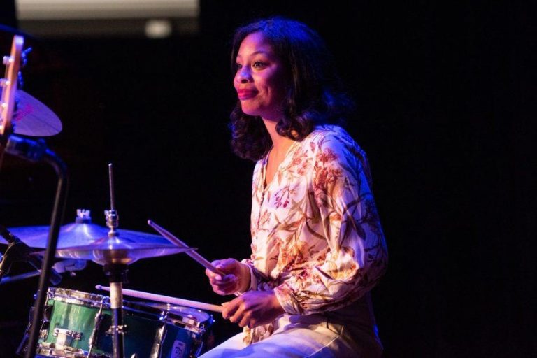 Vrouw zit achter een drumstel