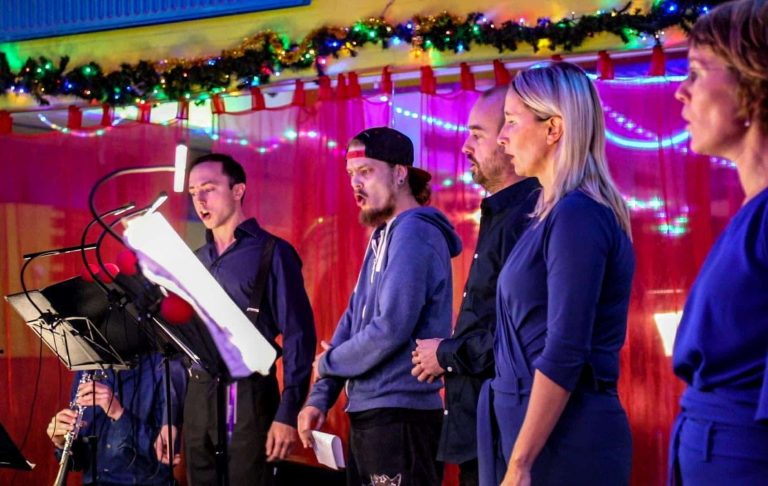 Foto van zangers tijdens optreden.