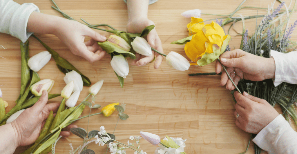 Handen die met bloemschikken bezig zijn