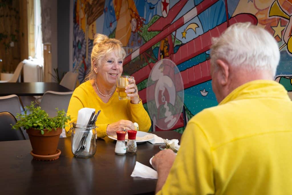 Oudere man en vrouw eten en drinken lunch