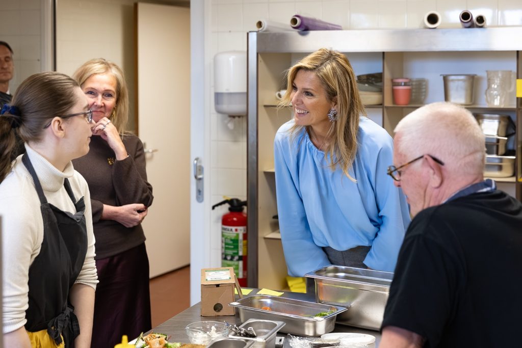 Maxima lachend in gesprek in de keuken bij Enik