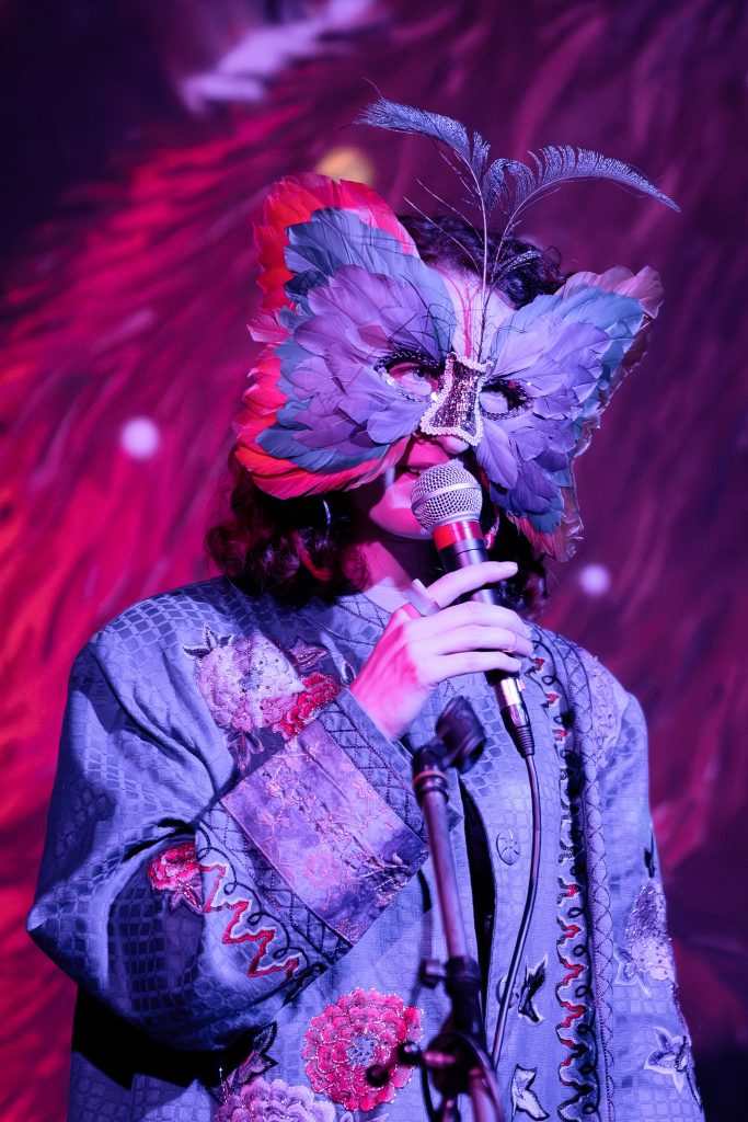 persoon met vlindermasker op zingt in microfoon op open podium Diversity Day