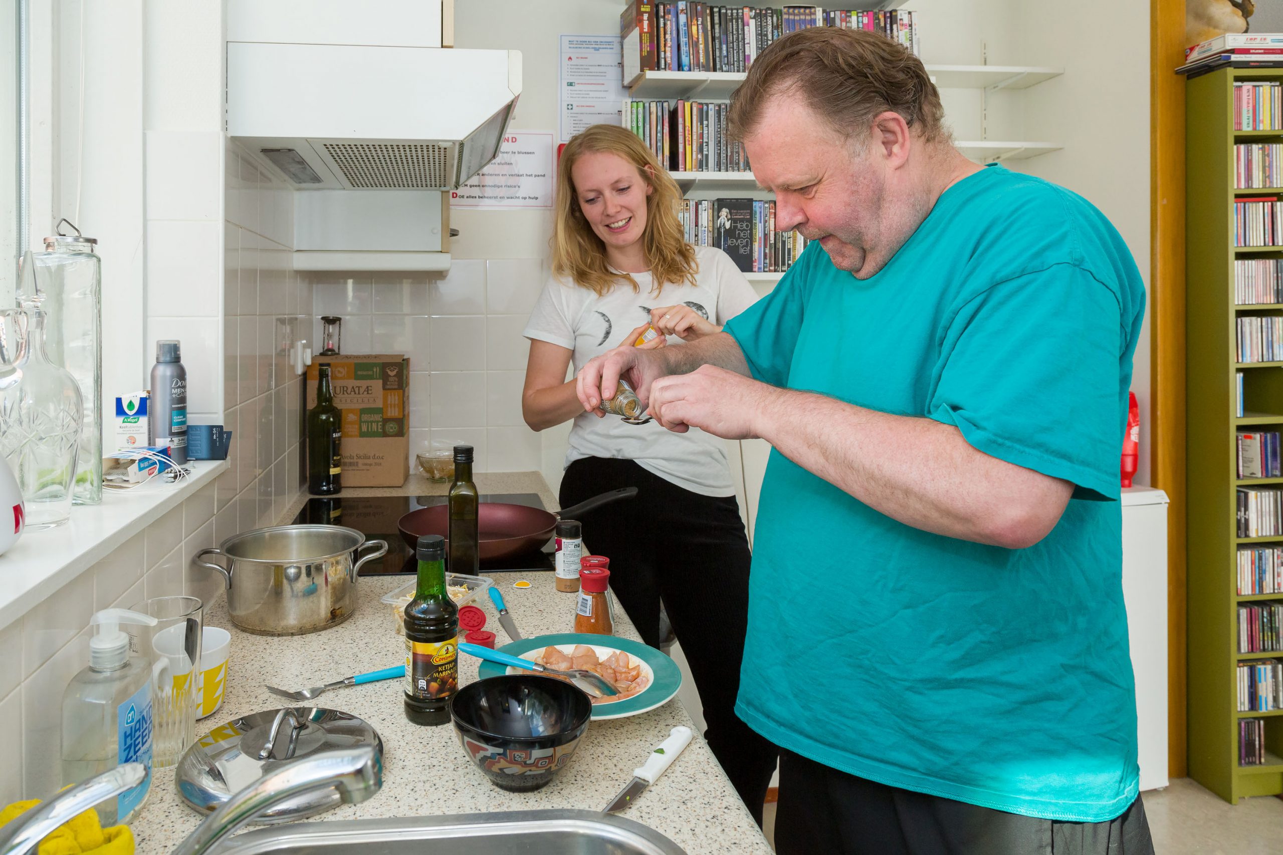 Twee personen zijn in de keuken samen aan het koken